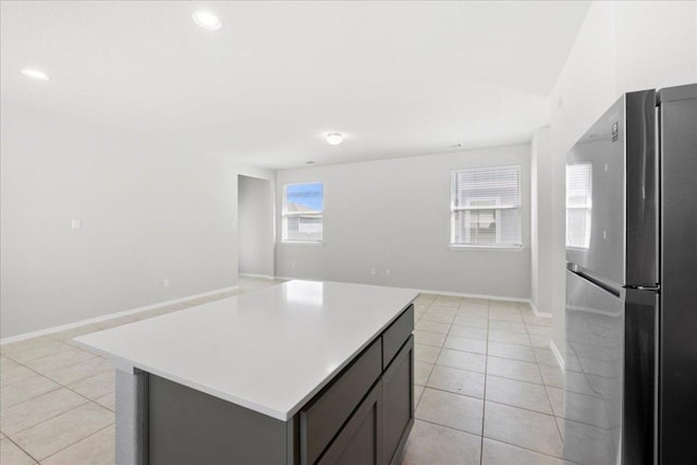252 Fabion St, Kyle, TX 78640 - kitchen with freestanding refrigerator, open floor plan, light tile patterned floors, light countertops, and recessed lighting
