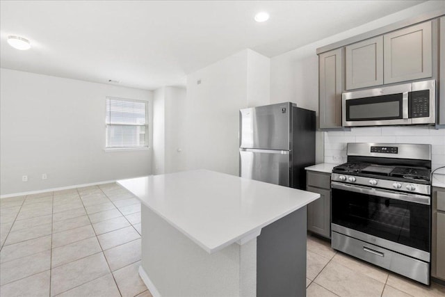252 Fabion St, Kyle, TX 78640 - kitchen with stainless steel appliances, gray cabinets, light tile patterned floors, light countertops, and recessed lighting