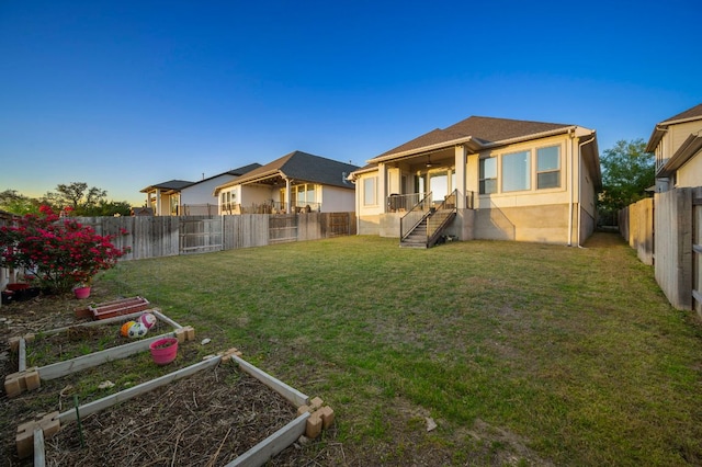344 Pisa Ln, Georgetown, TX 78628 - back of house featuring a vegetable garden and stucco siding
