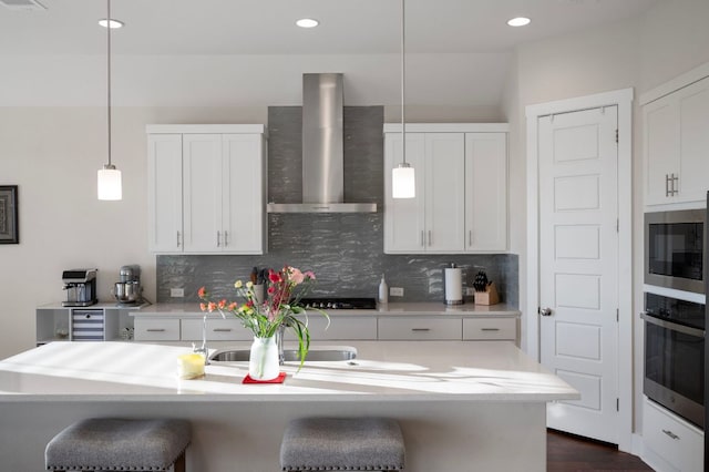 344 Pisa Ln, Georgetown, TX 78628 - kitchen featuring wall chimney range hood, stainless steel oven, a kitchen breakfast bar, tasteful backsplash, and recessed lighting