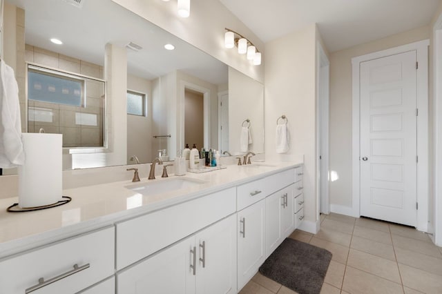 344 Pisa Ln, Georgetown, TX 78628 - bathroom featuring double vanity, tile patterned floors, a tile shower, and baseboards