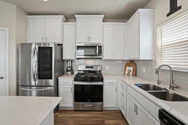 kitchen with tasteful backsplash, a sink, stainless steel appliances, white cabinetry, and dark wood-type flooring