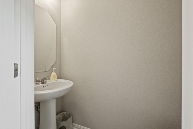 bathroom with baseboards and a sink