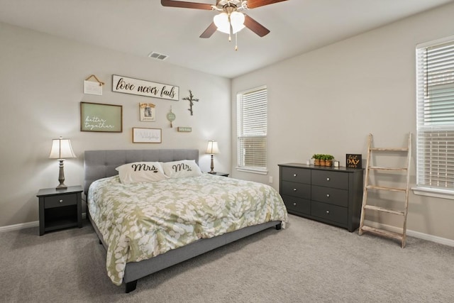carpeted bedroom featuring baseboards, ceiling fan, and visible vents