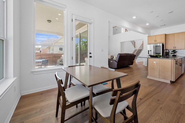 dining space with wood finished floors, stairway, recessed lighting, and baseboards