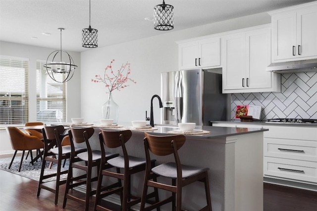 3307 Columbus Way, Round Rock, TX 78665 - kitchen featuring stainless steel refrigerator with ice dispenser, under cabinet range hood, dark wood-style floors, tasteful backsplash, and a chandelier