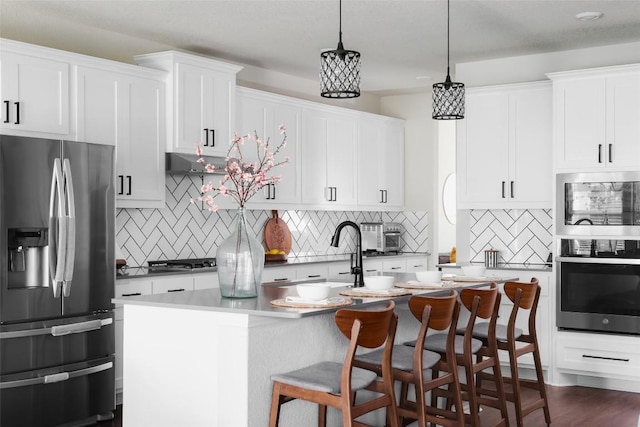3307 Columbus Way, Round Rock, TX 78665 - kitchen featuring appliances with stainless steel finishes, tasteful backsplash, a sink, a center island with sink, and a breakfast bar area