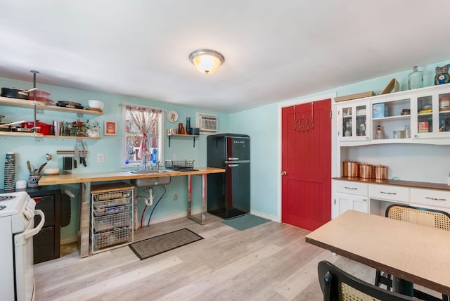 523 Ash St, Lockhart, TX 78644 - kitchen with a sink, freestanding refrigerator, open shelves, and stove