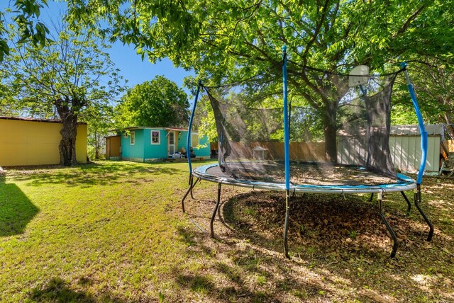 523 Ash St, Lockhart, TX 78644 - view of yard featuring a trampoline and an outdoor structure