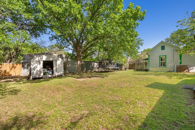 523 Ash St, Lockhart, TX 78644 - view of yard with a trampoline, a shed, a fenced backyard, and an outbuilding