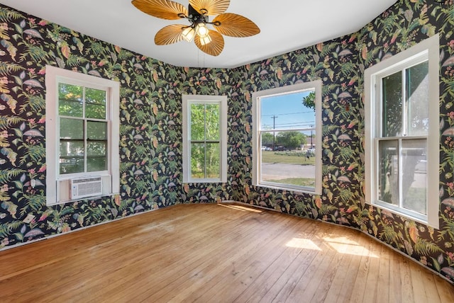 523 Ash St, Lockhart, TX 78644 - unfurnished room featuring plenty of natural light, wood-type flooring, cooling unit, and wallpapered walls