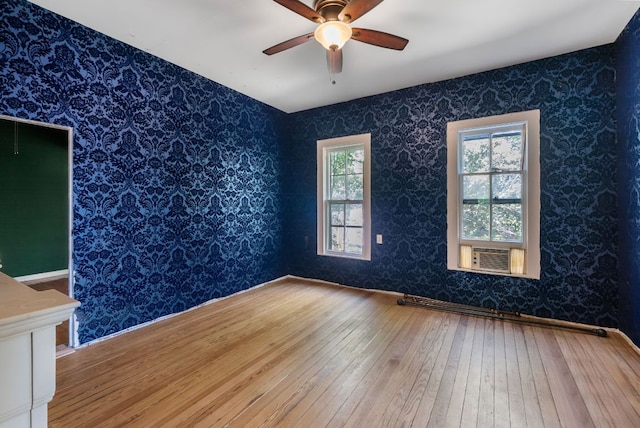 523 Ash St, Lockhart, TX 78644 - unfurnished room with cooling unit, wallpapered walls, wood-type flooring, and a ceiling fan