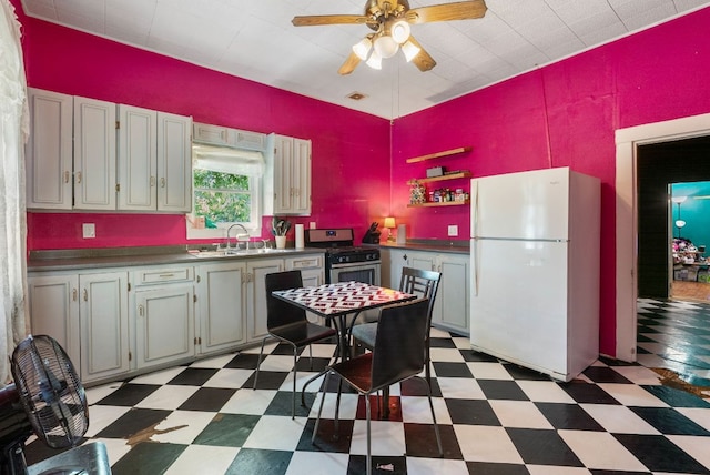 523 Ash St, Lockhart, TX 78644 - kitchen with a sink, stainless steel gas range oven, freestanding refrigerator, and light floors