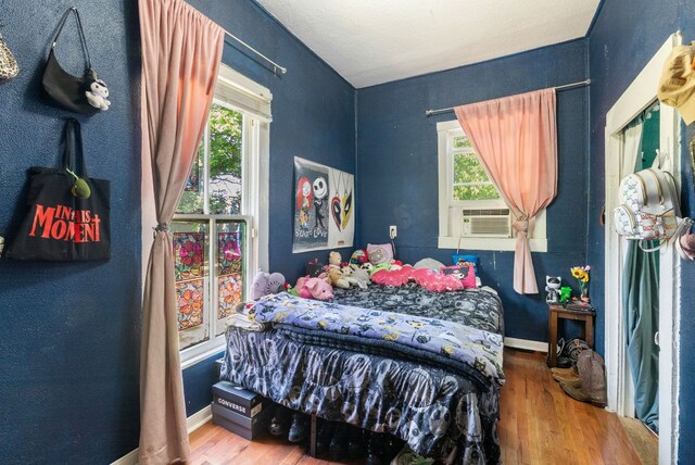 523 Ash St, Lockhart, TX 78644 - bedroom with baseboards, cooling unit, and wood finished floors