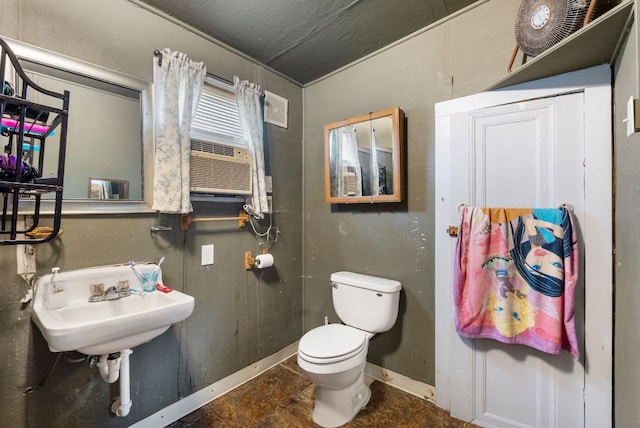 523 Ash St, Lockhart, TX 78644 - half bath featuring baseboards, cooling unit, a sink, and toilet