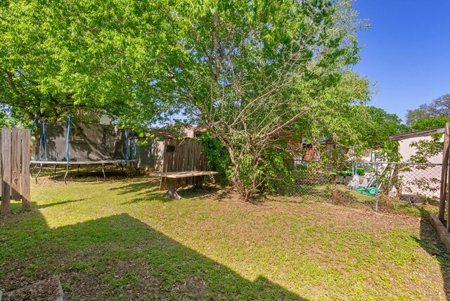 523 Ash St, Lockhart, TX 78644 - view of yard featuring a trampoline and fence