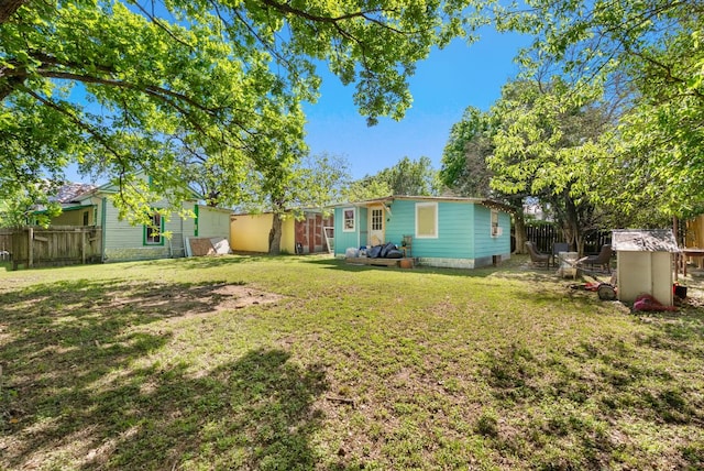 523 Ash St, Lockhart, TX 78644 - rear view of house with an outdoor structure, fence, and a lawn