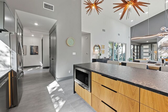 5908 Lakeside Trl, Austin, TX 78734 - kitchen featuring stainless steel appliances, modern cabinets, a high ceiling, open floor plan, and baseboards