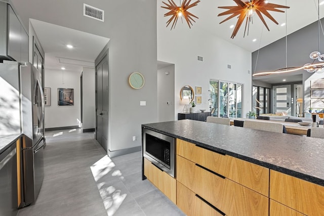 5908 Lakeside Trl, Austin, TX 78734 - kitchen featuring appliances with stainless steel finishes, modern cabinets, a towering ceiling, open floor plan, and dark stone countertops