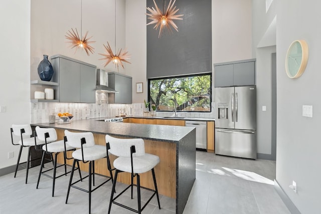5908 Lakeside Trl, Austin, TX 78734 - kitchen featuring stainless steel appliances, wall chimney exhaust hood, gray cabinetry, a high ceiling, and a sink