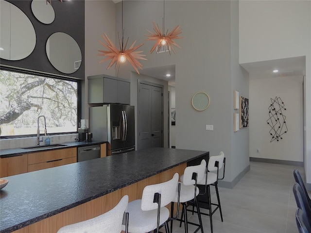 5908 Lakeside Trl, Austin, TX 78734 - kitchen with a towering ceiling, appliances with stainless steel finishes, a sink, a kitchen breakfast bar, and modern cabinets