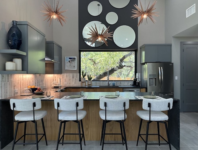 5908 Lakeside Trl, Austin, TX 78734 - kitchen with a high ceiling, stainless steel fridge, a peninsula, modern cabinets, and backsplash