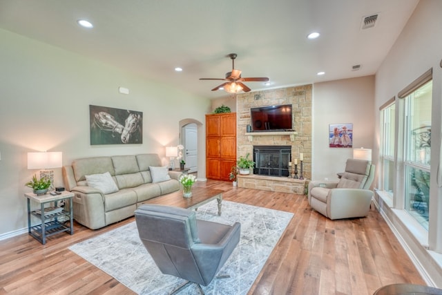 103 Ladera Cv, Marble Falls, TX 78654 - living area with arched walkways, a ceiling fan, a fireplace, recessed lighting, and light wood-style floors