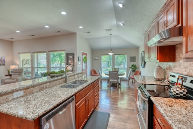 103 Ladera Cv, Marble Falls, TX 78654 - kitchen with stainless steel appliances, under cabinet range hood, a sink, light wood finished floors, and brown cabinets