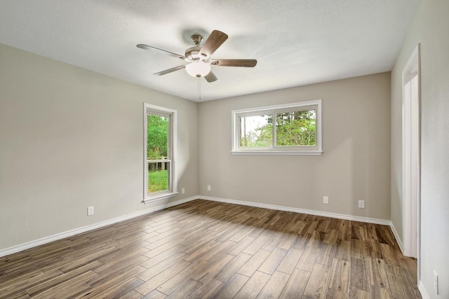 unfurnished room with wood finished floors, ceiling fan, and baseboards