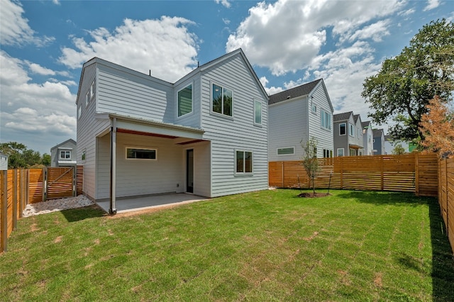rear view of house featuring a fenced backyard, a patio area, and a yard
