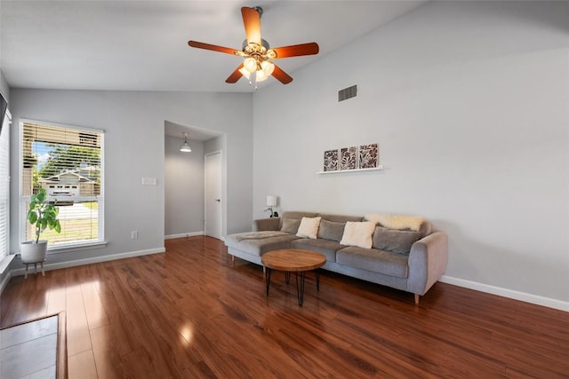 living area featuring vaulted ceiling, wood finished floors, ceiling fan, and baseboards