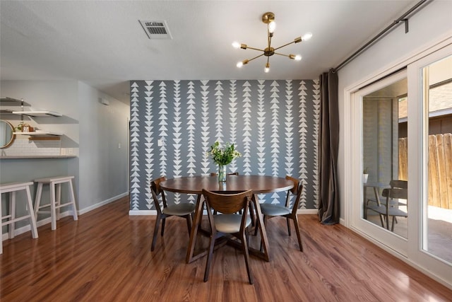 dining area with a chandelier, wood finished floors, and baseboards