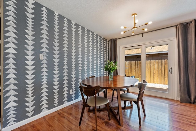 dining area featuring a chandelier, wood finished floors, and baseboards