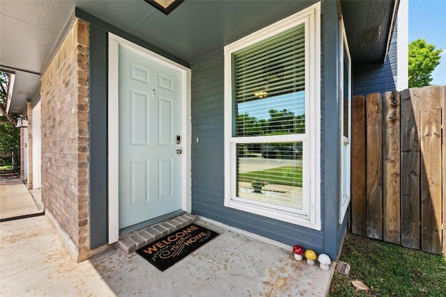 doorway to property with covered porch and brick siding