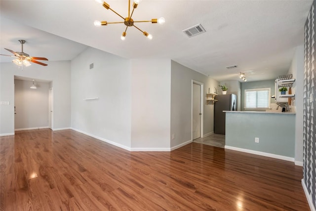 14585 Robert I Walker Blvd, Austin, TX 78728 - unfurnished living room featuring wood finished floors, a chandelier, and a ceiling fan