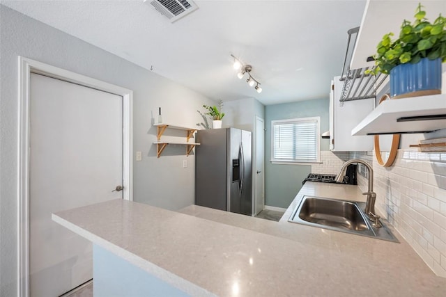 14585 Robert I Walker Blvd, Austin, TX 78728 - kitchen with stainless steel refrigerator with ice dispenser, open shelves, backsplash, a peninsula, and light countertops