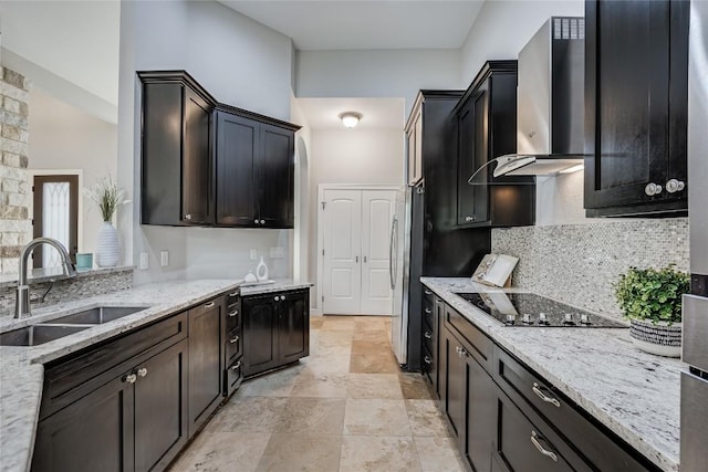 21434 Lakefront Dr, Lago Vista, TX 78645 - kitchen with black electric cooktop, wall chimney range hood, freestanding refrigerator, backsplash, and light stone counters
