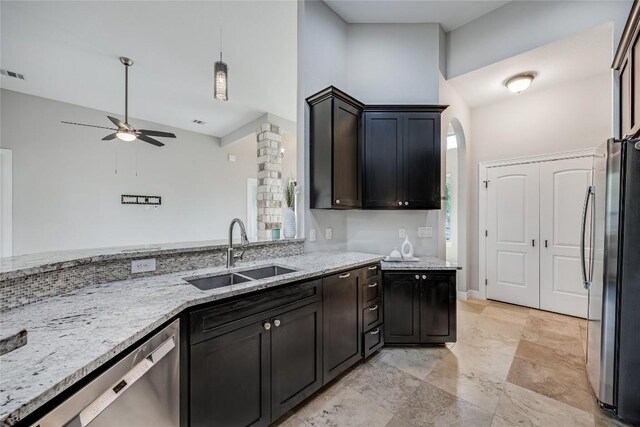 21434 Lakefront Dr, Lago Vista, TX 78645 - kitchen featuring appliances with stainless steel finishes, a ceiling fan, light stone counters, high vaulted ceiling, and decorative light fixtures