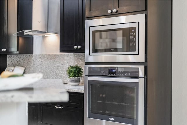 21434 Lakefront Dr, Lago Vista, TX 78645 - kitchen featuring stainless steel appliances, wall chimney range hood, and backsplash