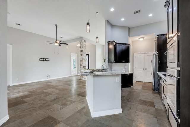 21434 Lakefront Dr, Lago Vista, TX 78645 - kitchen with stainless steel appliances, a towering ceiling, open floor plan, a peninsula, and a ceiling fan