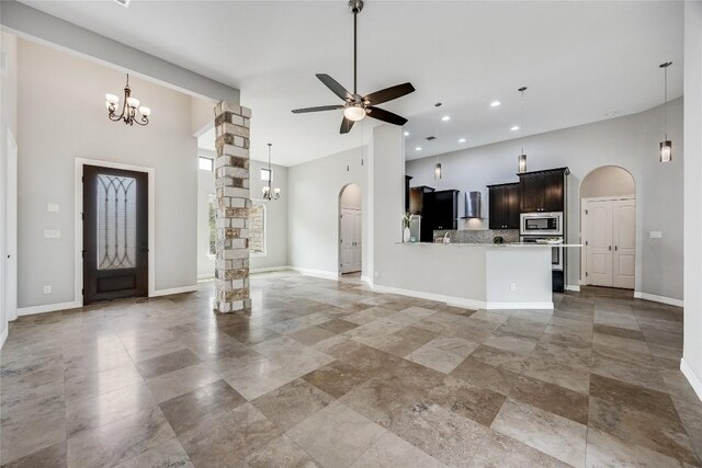 21434 Lakefront Dr, Lago Vista, TX 78645 - unfurnished living room featuring arched walkways, a chandelier, a towering ceiling, ceiling fan, and recessed lighting