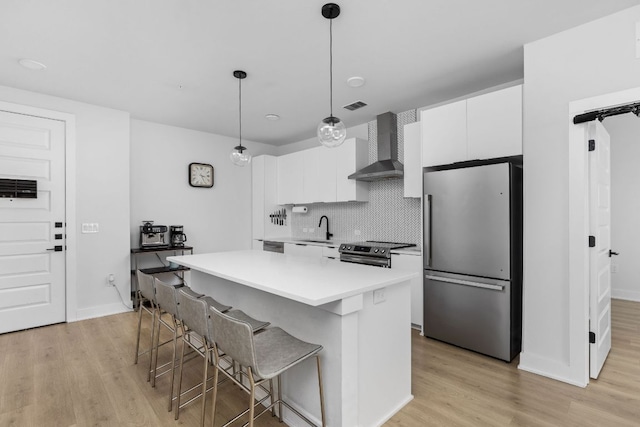 2500 Longview St Unit 418, Austin, TX 78705 - kitchen with appliances with stainless steel finishes, wall chimney exhaust hood, light wood-type flooring, and white cabinets