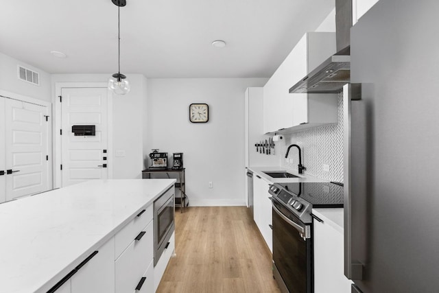 2500 Longview St Unit 418, Austin, TX 78705 - kitchen featuring a sink, electric range oven, wall chimney range hood, stainless steel microwave, and white cabinets