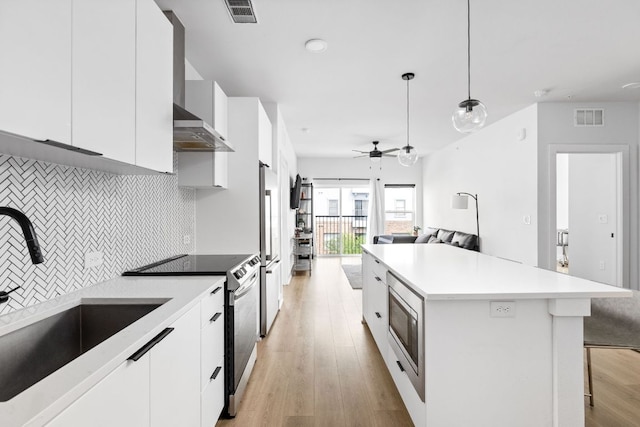 2500 Longview St Unit 418, Austin, TX 78705 - kitchen with electric range, a sink, light wood-type flooring, white cabinetry, and ceiling fan