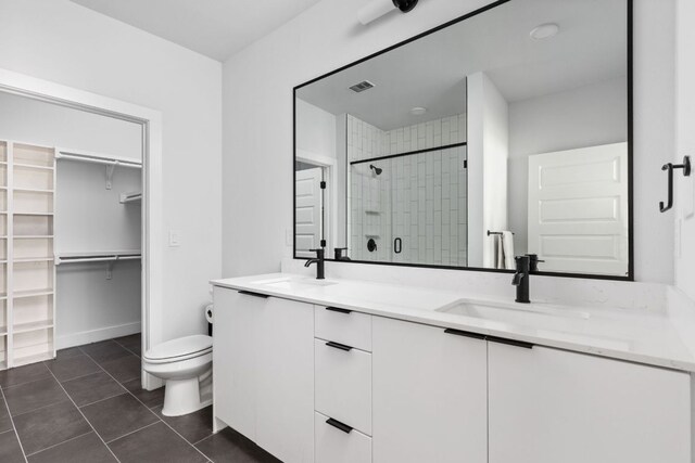 2500 Longview St Unit 418, Austin, TX 78705 - full bathroom featuring a stall shower, double vanity, toilet, a spacious closet, and tile patterned flooring