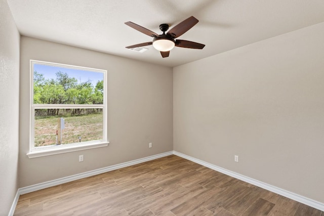 125 Channel Dr, Sunrise Beach, TX 78643 - unfurnished room with baseboards, visible vents, wood finished floors, and a ceiling fan