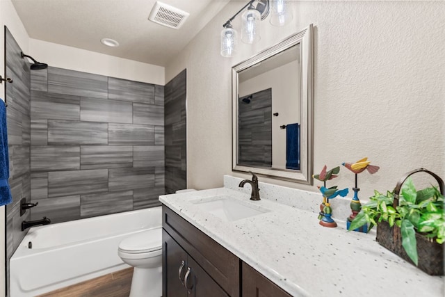 125 Channel Dr, Sunrise Beach, TX 78643 - full bath featuring vanity, toilet, visible vents, a textured wall, and shower / washtub combination
