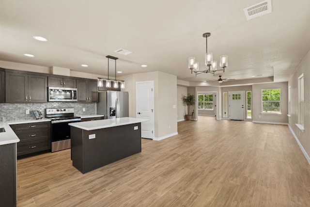 125 Channel Dr, Sunrise Beach, TX 78643 - kitchen featuring appliances with stainless steel finishes, a kitchen island, light countertops, baseboards, and visible vents