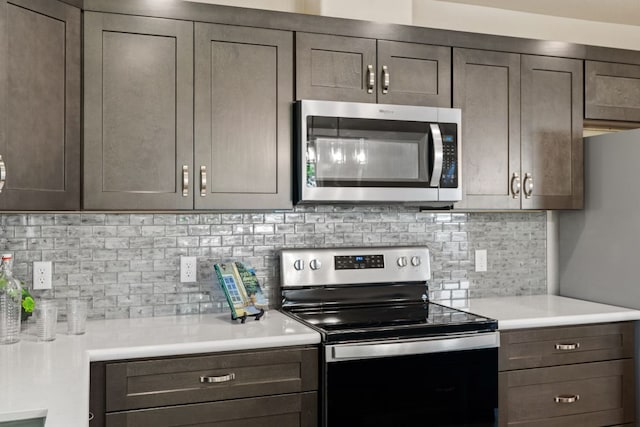 125 Channel Dr, Sunrise Beach, TX 78643 - kitchen with dark brown cabinetry, backsplash, appliances with stainless steel finishes, and light countertops