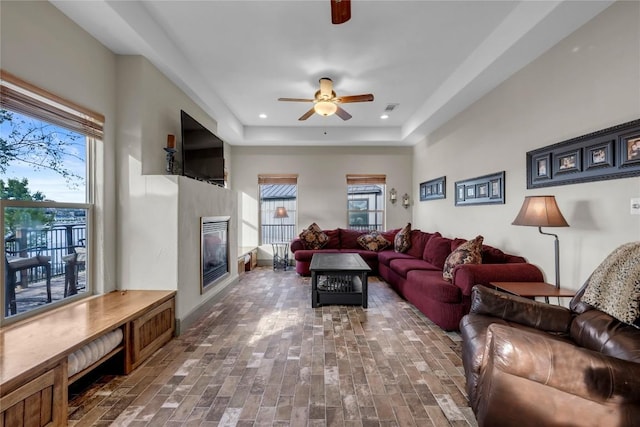 202 Bridgepoint Dr, Kingsland, TX 78639 - living room featuring a ceiling fan, healthy amount of natural light, a glass covered fireplace, recessed lighting, and a raised ceiling